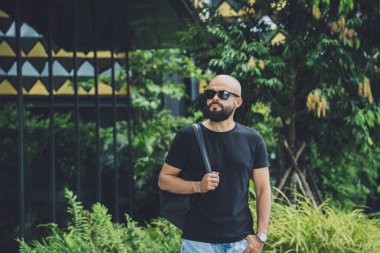 Ormanda yeşil yaprakları olan genç bir adamın portresi..