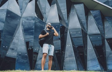 Modadan bir gencin portresi telefonda konuşuyor. Güzel, karanlık şehir arka planında..