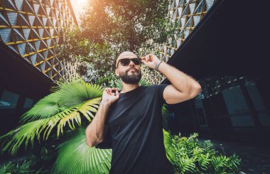 Ormanda yeşil yaprakları olan genç bir adamın portresi..