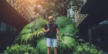 Ormanda yeşil yaprakları olan genç bir adamın portresi..