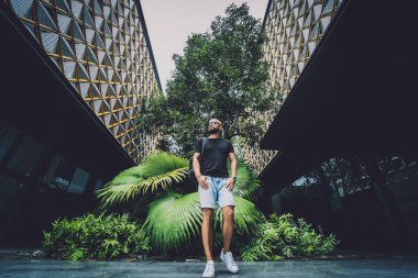 Ormanda yeşil yaprakları olan genç bir adamın portresi..