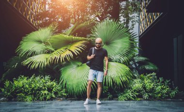 Ormanda yeşil yaprakları olan genç bir adamın portresi..