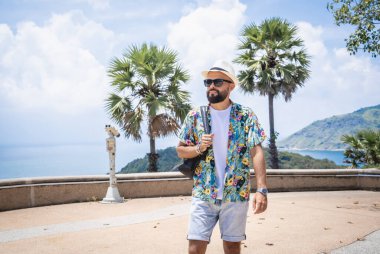 Arka planda dürbünlü teleskopla yürüyen bir adam.