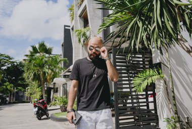 Genç işadamı garajı ve arabasıyla modern evinden çıkıyor..