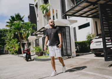 Genç işadamı garajı ve arabasıyla modern evinden çıkıyor..