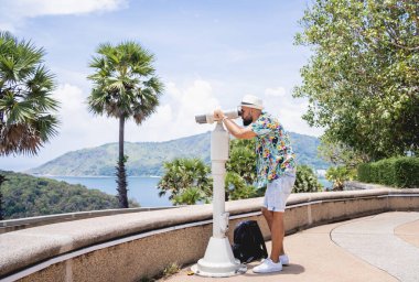 Gözlem noktasında duran dürbünden izleyen bir adam..