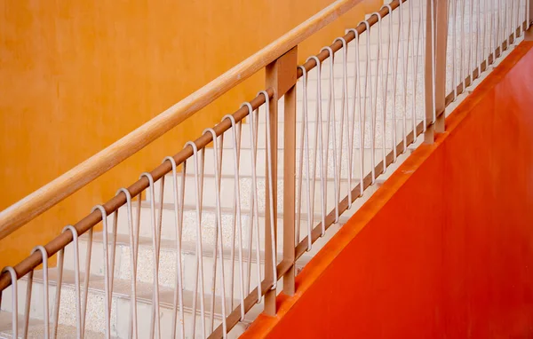 Metal stairs on the big orange wall.