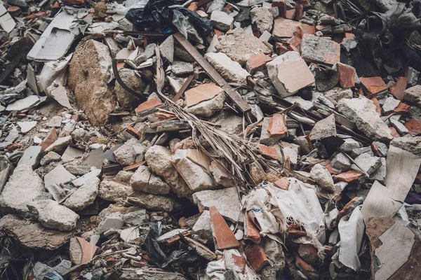 Waste plastic bottles and other types of waste at the ground.