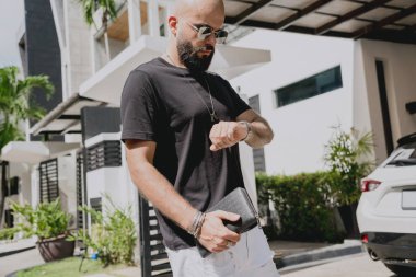 Genç işadamı garajı ve arabasıyla modern evinden çıkıyor..