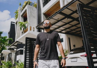 Genç işadamı garajı ve arabasıyla modern evinden çıkıyor..