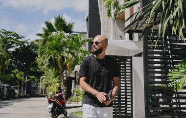 Genç işadamı garajı ve arabasıyla modern evinden çıkıyor..