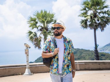 Arka planda dürbünlü teleskopla yürüyen bir adam.