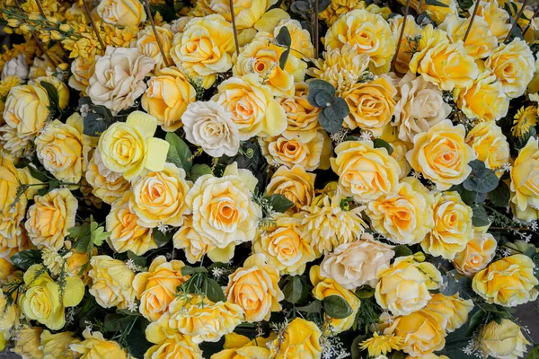 Big bouquet of flowers in a vase on a gray wall background.