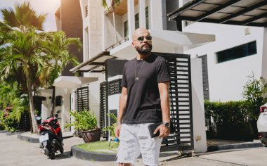 Genç işadamı garajı ve arabasıyla modern evinden çıkıyor..