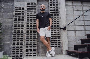 Şehrin sokaklarında tişörtlü ve şortlu genç bir adam..