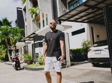 Genç işadamı garajı ve arabasıyla modern evinden çıkıyor..