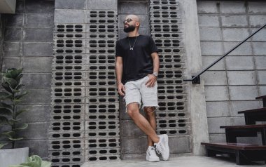 Şehrin sokaklarında tişörtlü ve şortlu genç bir adam..