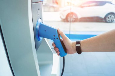 Man charge his electric car at city charging station.