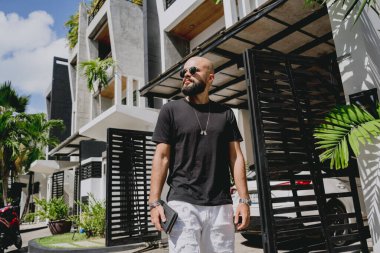 Genç işadamı garajı ve arabasıyla modern evinden çıkıyor..