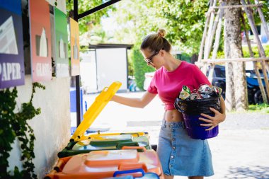 Genç ve güzel bir kız özel çöp kutularına çöp atıyor..
