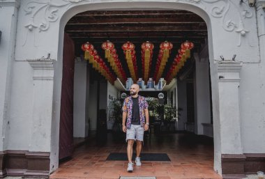 Asya tapınağının arka planında sırt çantası olan genç bir adam..