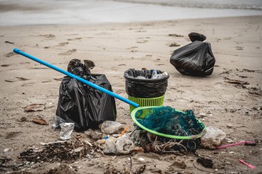 Plajda toplanan plastik ve diğer atıklarla dolu büyük çantalar..