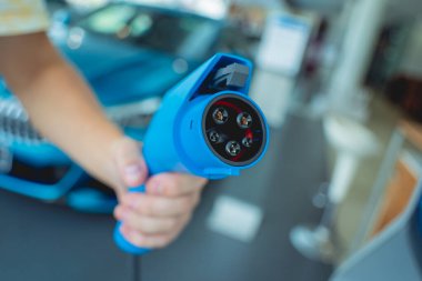 Man charge his electric car at city charging station.