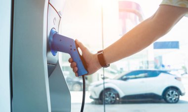 Man charge his electric car at city charging station.