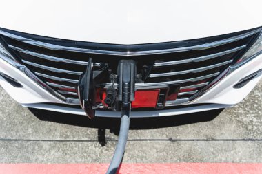 Charging electric car from station at the city street.