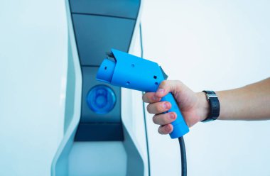 Man charge his electric car at city charging station.