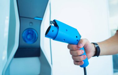 Man charge his electric car at city charging station.