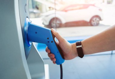 Man charge his electric car at city charging station.