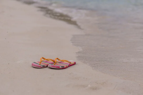 Flipflops op een zanderige oceaan strand — Stockfoto