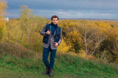 Uzun boylu yakışıklı bir adam fırtınadan önce sarı sonbahar ormanında yürüyordu.