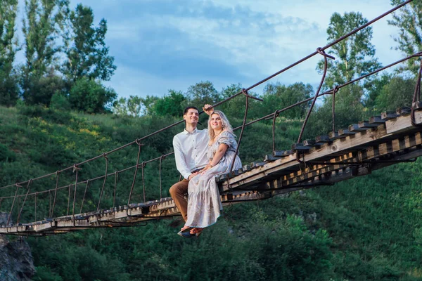 Vackra Unga Romantiska Par Sitter Och Kramas Hängbron Ovanför Floden — Stockfoto