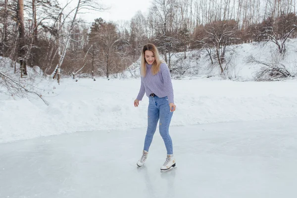 可爱的年轻女子在溜冰场上滑冰 在寒冷的冬日里 女孩在冰上滑冰 免版税图库图片