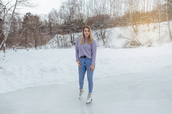 アイスリンクでアイススケートに乗る素敵な若い女性 冬の霜の日に氷の上でスケート女の子 — ストック写真