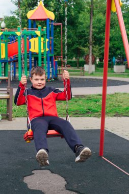Dışarıda parkta salıncakta sallanan sevimli bir çocuğun portresi..
