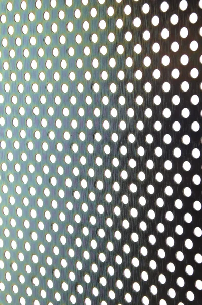 Блискучий металевий фон пластини з симетричними отворами — стокове фото