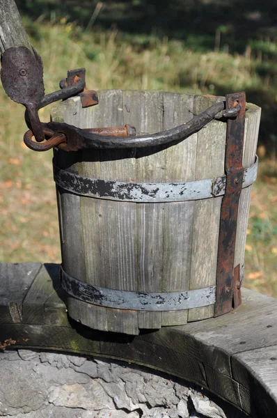 Hölzerner leerer Eimer am Brunnen, Symbol für Dürre und Armut — Stockfoto