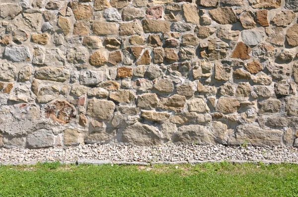 Sandsteinmauer und grünes Gras — Stockfoto