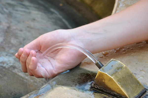 Hand under drinking water fountain — Stock Photo, Image