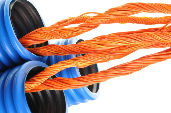 Blue corrugated pipe with orange cables — Stock Photo, Image