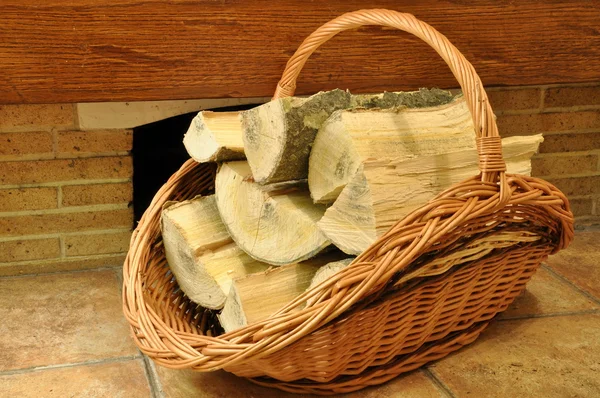 Firewood in a wicker basket — Stock Photo, Image