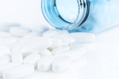 Plastik bir şişeden dökülen haplar.