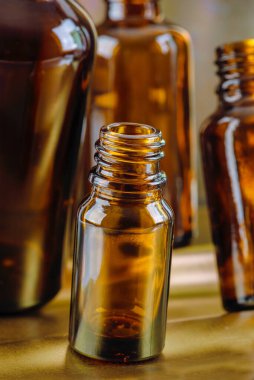 İlaç, koku, esans yağı ve metalik arka planda iksir için küçük kehribar renkli cam şişeler açtım.