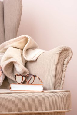 Boş koltuk üzerine kitap ve gözlük, kopyalama alanı ile yakın plan görünüm