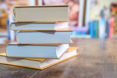 Bulanık yumuşak kütüphane arka planına sahip kitap yığını