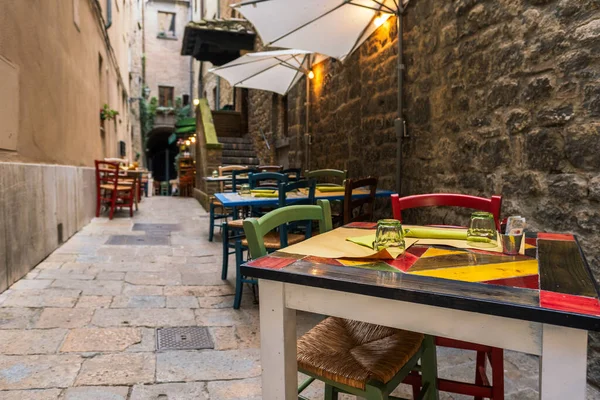 意大利特拉托里亚狭窄小巷里的桌子和椅子 — 图库照片