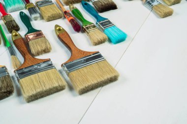 Tahta masadaki boya fırçaları, fotokopi alanı ile düzleştirilmiş.